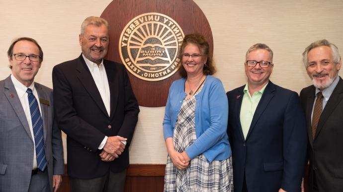 Danny Anderson and The Financial Literacy of South Texas Foundation members in front of the Trinity emblem. 