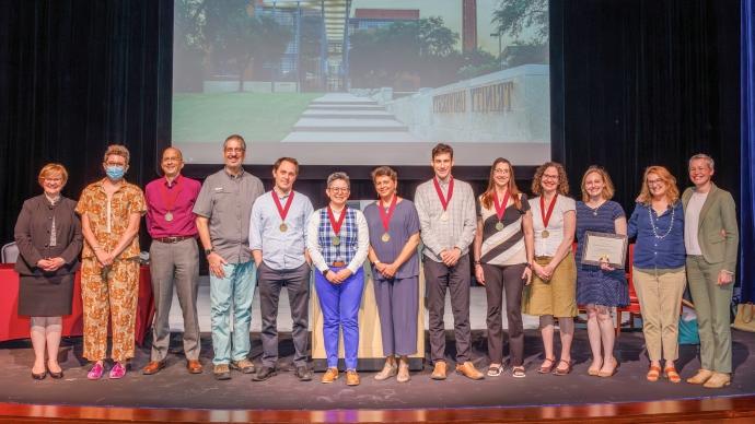 The faculty and staff award winners stand on stage