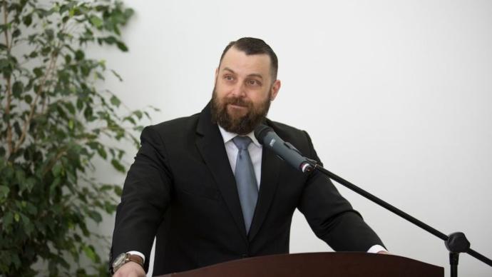 Justin Mynar '02 giving a speech at a stand