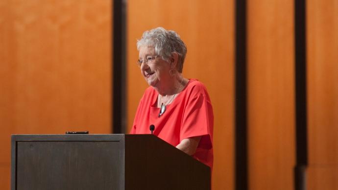 Coleen Grissom stands at a podium smiling