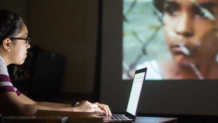 Student Megan Medrano uses her laptop while analyzing a 电影