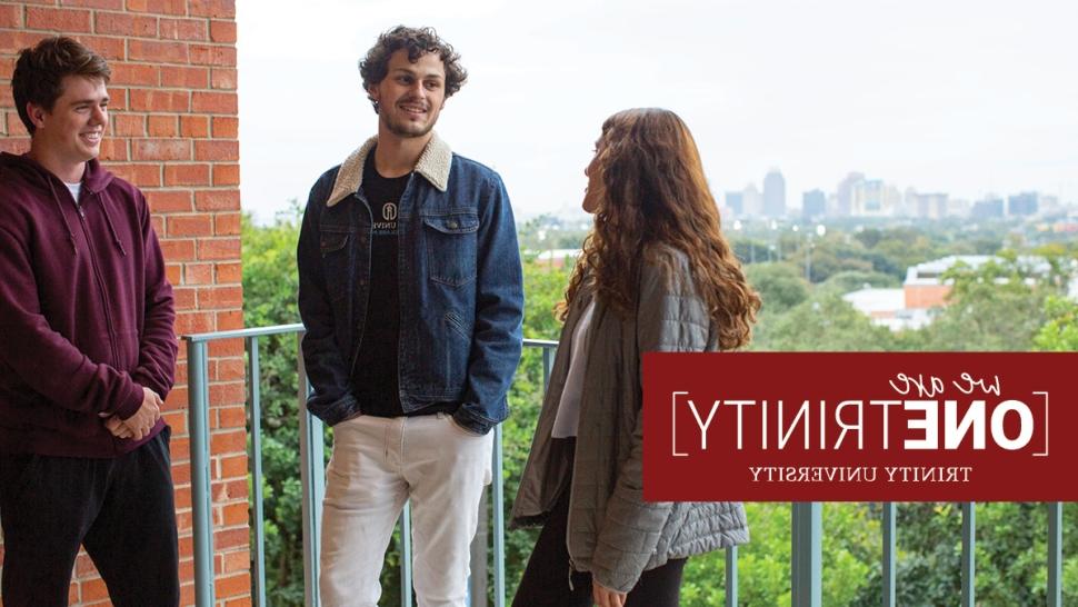 Austin Champagne poses with his friends on a skyline balcony