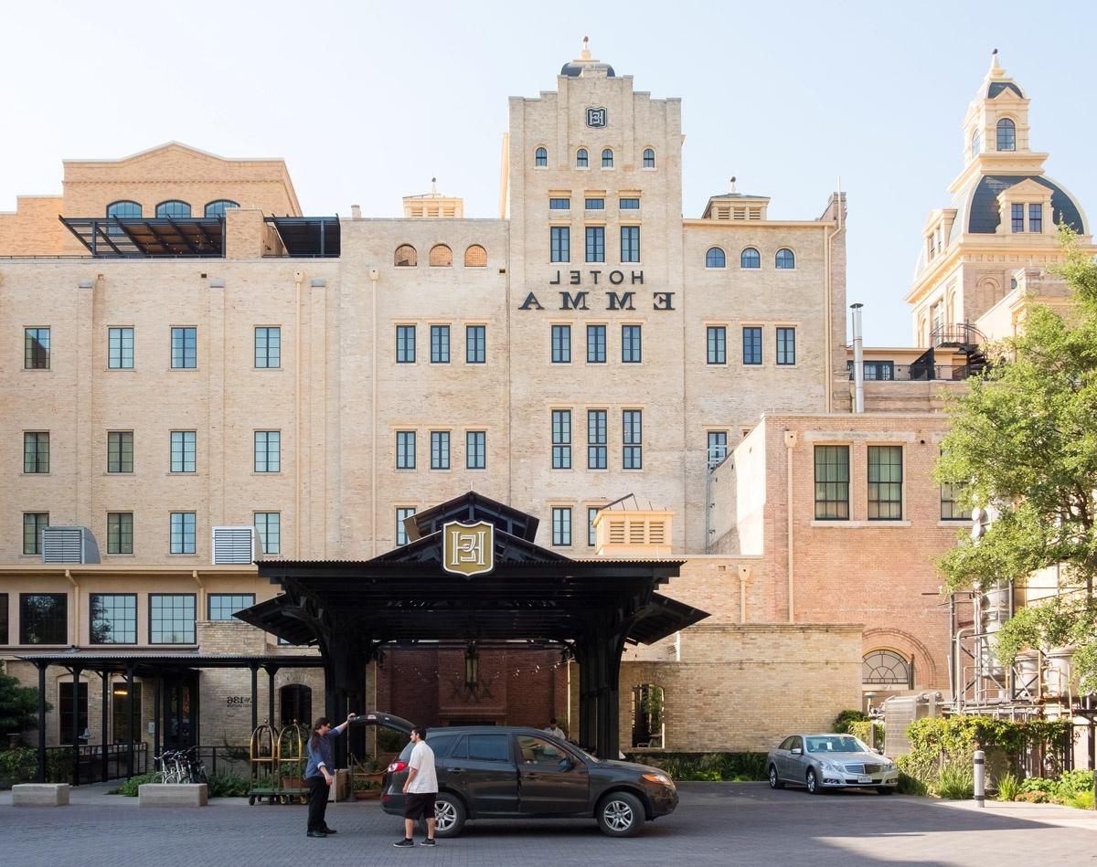 the Hotel Emma from the riverwalk; a man is unloading his car