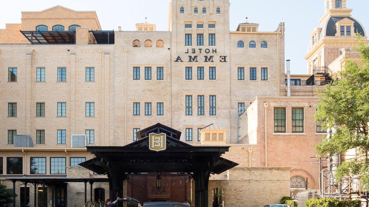 the Hotel Emma from the riverwalk; a man is unloading his car