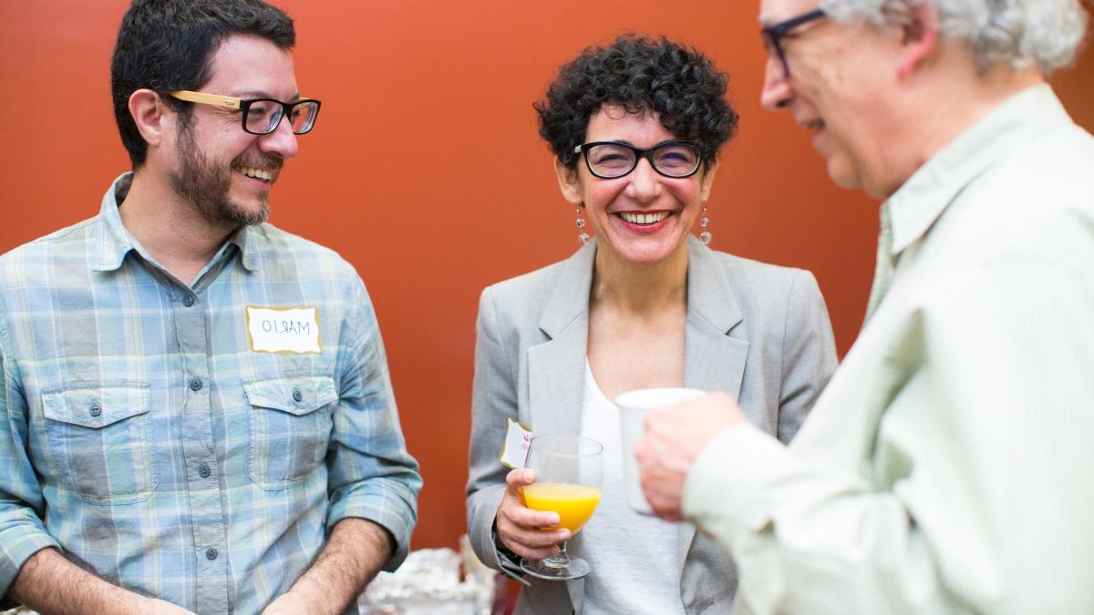 three faculty members chat over breakfast